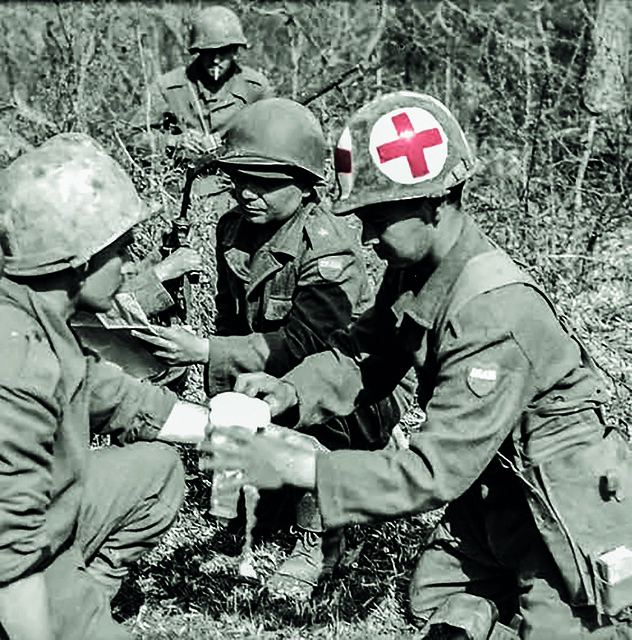 (Medici della F.E.B. mentre curano alcuni soldati feriti)